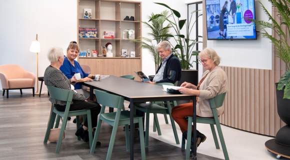 Vier bezoekers zitten in de wachtruimte van het Gezondheidsplein