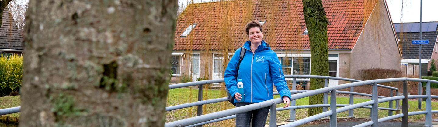 Medewerker van Omring thuiszorg poseert middenin de wijk.