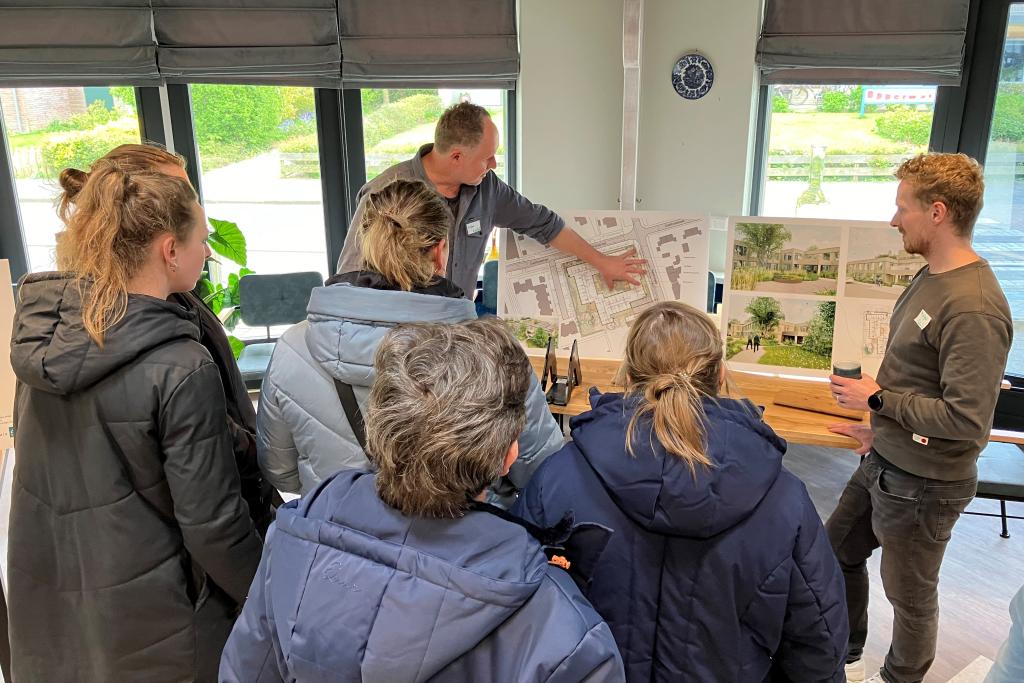 Toelichting medewerker bouwconsortium aan bezoekers bij infoborden